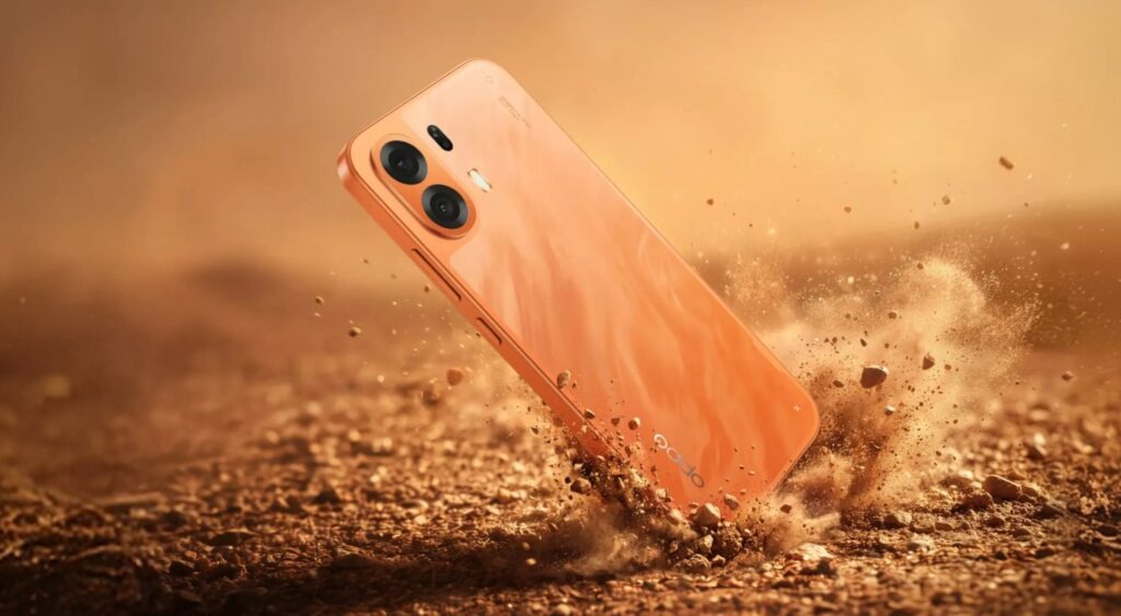 OPPO K14 Plus 5G в оранжевом корпусе на фоне песка
