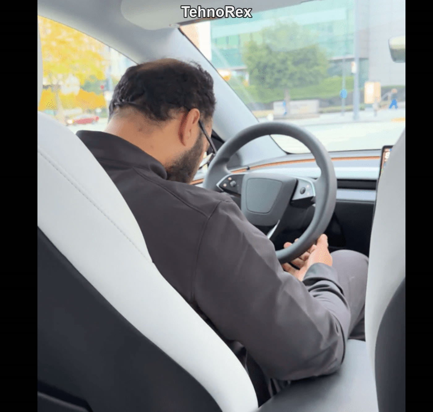 Крупный кадр водителя Tesla: взгляд вниз, телефон в зоне рук