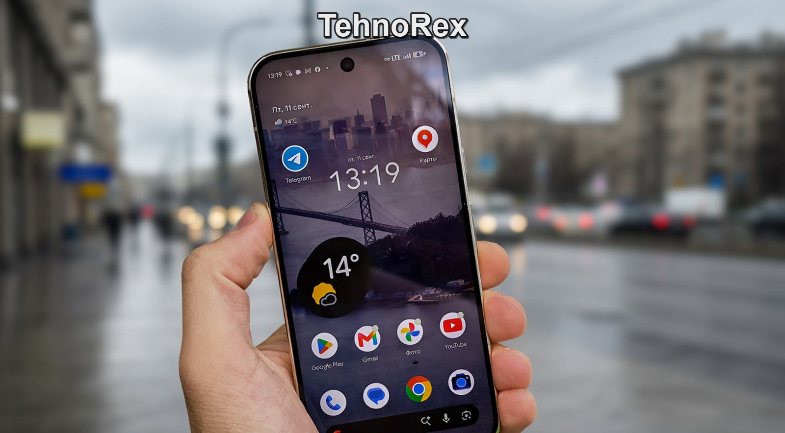 Google Pixel 11 Pro в руке с включённым экраном на улице